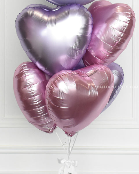 Lilac and pink heart foil balloons inflated with helium, closer image